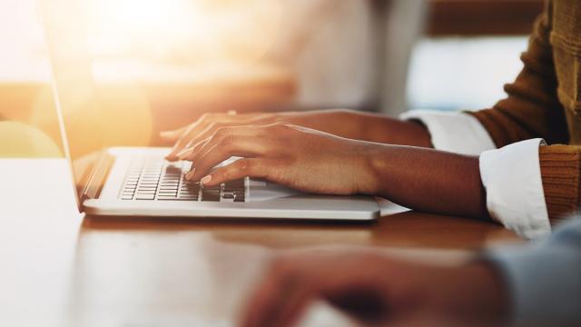 Henkilö kirjoittaa läppärillä.