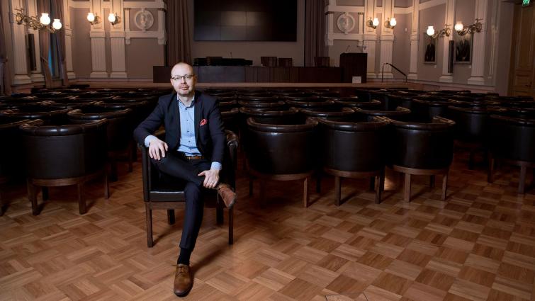 Jyväskylän kaupunginjohtaja Timo Koivisto istuu tyhjässä, näyttävässä salissa
