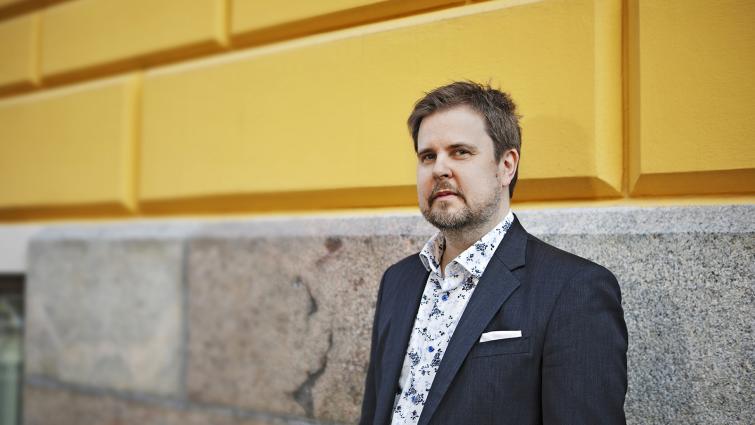 Jani Pitkäniemi, valtionvarainministeriön kunta- ja aluehallinto-osaston osastopäällikkö seisomassa keltaisen talon edessä.