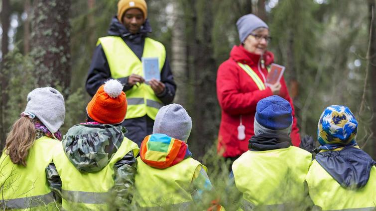 Lapset istuvat metsässä varhaiskasvatuksen opettajien kanssa. Kuva: Hanna Matikainen /Lehtikuva.