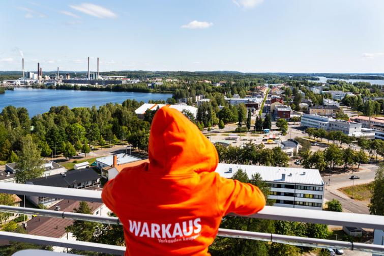 Varkauden henkilöstöjohtaja Nina Holopainen katselee Varkautta ylhäältä, päällään Warkaus-huppari